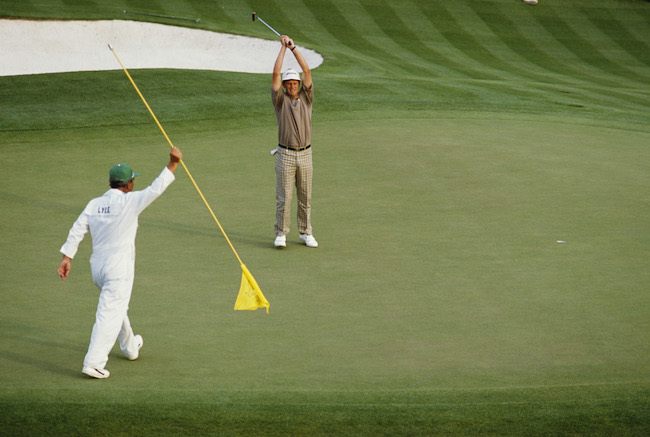 Caddy Dave Musgrove looks on as Sandy Lyle of Great Britain holes out his putt on the final 18th hole to win the US Masters Golf Tournament on 10th April 1988 at the Augusta National Golf Club in Augusta, Georgia, United States. (Photo by David Cannon/Getty Images)